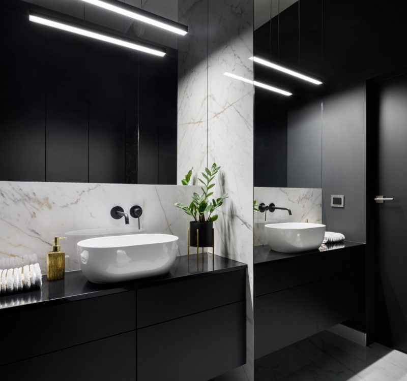 Elegant black bathroom with mirror wall and decorative marble tiles